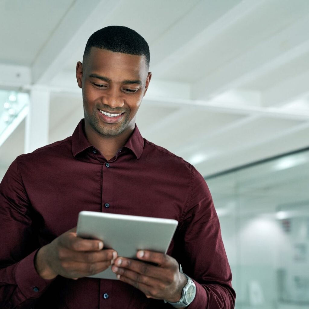 person smiling while looking at their tablet