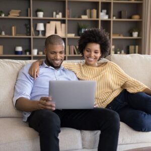 couple sitting on the couch with a laptop